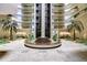 Elegant building lobby featuring a beautiful fountain, palm trees, and multiple floors with lush greenery at 2413 Bayshore Blvd # 1903, Tampa, FL 33629