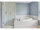 Bathroom featuring a shower with glass door and separate soaking tub at 25737 Frith St, Land O Lakes, FL 34639