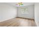 Bedroom featuring wood-look flooring, a unique ceiling fan, and a window for natural light at 25737 Frith St, Land O Lakes, FL 34639