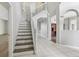 Bright foyer features white staircase, tile floors, and arched entryways, offering a welcoming ambiance at 25737 Frith St, Land O Lakes, FL 34639
