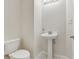 Cozy half bathroom featuring pedestal sink and toilet at 25737 Frith St, Land O Lakes, FL 34639