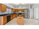 Well-equipped kitchen with wood cabinetry, stainless steel refrigerator, and central island at 25737 Frith St, Land O Lakes, FL 34639