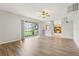 Spacious living room with wood floors, ceiling fan, and sliding glass doors leading to backyard view at 25737 Frith St, Land O Lakes, FL 34639