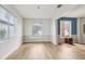Bright living room with wood-look flooring, wainscoting, and natural light from large windows at 25737 Frith St, Land O Lakes, FL 34639