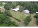 Aerial view of a home and metal storage building, enhanced by mature trees and lush green lawn at 2610 Crestview Rd, Wimauma, FL 33598
