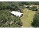 Aerial view of a home surrounded by mature trees on an expansive lot, complemented by blue skies at 2610 Crestview Rd, Wimauma, FL 33598