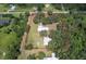Aerial view of a property with home, outbuildings, surrounded by mature trees, delineated by property lines at 2610 Crestview Rd, Wimauma, FL 33598