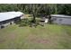 Lush backyard featuring an outbuilding, mature trees, and an expansive grassy area at 2610 Crestview Rd, Wimauma, FL 33598
