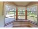 Close-up of a charming bay window with lace curtains, offering a view of the surrounding greenery at 2610 Crestview Rd, Wimauma, FL 33598
