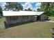 Charming single-story home featuring a metal roof, classic shuttered windows, and a well-manicured lawn at 2610 Crestview Rd, Wimauma, FL 33598