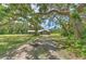 Charming single-story home with a metal roof, nestled under mature oak trees and a large front yard at 2610 Crestview Rd, Wimauma, FL 33598