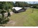 Aerial view of a well-maintained home showcasing a metal roof, and green lawn at 2610 Crestview Rd, Wimauma, FL 33598