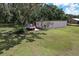 View of a backyard outbuilding with a red and white truck parked alongside on a grassy lot at 2610 Crestview Rd, Wimauma, FL 33598