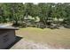 Property showcasing a home and a lush green lawn surrounded by mature trees with Spanish moss at 2610 Crestview Rd, Wimauma, FL 33598