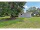 Large backyard has mature trees, lush lawn, wood deck, and partially fenced in area at 26223 Chianina Dr, Wesley Chapel, FL 33544