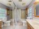Dual toilet bathroom featuring mirrored closet and wood cabinets at 26223 Chianina Dr, Wesley Chapel, FL 33544