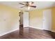 A bedroom with yellow walls, wood-look floors, and ceiling fan with overhead lighting at 26223 Chianina Dr, Wesley Chapel, FL 33544