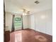 Bedroom features a window overlooking the yard, white walls, and wood-look floors at 26223 Chianina Dr, Wesley Chapel, FL 33544
