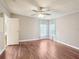 Comfortable bedroom with neutral walls, hardwood floors, and breezy curtains at 26223 Chianina Dr, Wesley Chapel, FL 33544