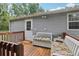 Outdoor deck features a bench with cushions, a small table and a white entry door at 26223 Chianina Dr, Wesley Chapel, FL 33544