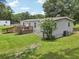 Backyard view of single-story home with deck, ramp, green lawn, and landscaping at 26223 Chianina Dr, Wesley Chapel, FL 33544
