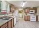 Functional kitchen with white appliances and wood cabinets; includes laundry area at 26223 Chianina Dr, Wesley Chapel, FL 33544