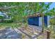Backyard patio area featuring a wooden pergola, lush greenery and a relaxing hammock at 301 Kingston S St, St Petersburg, FL 33711