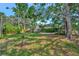 Spacious backyard featuring mature trees, lush grass, and a hammock for relaxing in the shade at 301 Kingston S St, St Petersburg, FL 33711