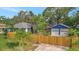 Large backyard with a detached two car garage, wooden fence and lush landscaping at 301 Kingston S St, St Petersburg, FL 33711