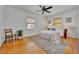 Bedroom with hardwood floors, ceiling fan, neutral rug, and natural light from two windows at 301 Kingston S St, St Petersburg, FL 33711