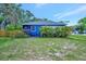 Charming home boasting blue exterior paint, mature landscaping and lush greenery at 301 Kingston S St, St Petersburg, FL 33711