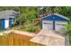 Aerial shot of blue home with a detached two-car garage and landscaped backyard at 301 Kingston S St, St Petersburg, FL 33711