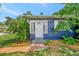 Charming home featuring a white front door, blue exterior and well-maintained landscaping at 301 Kingston S St, St Petersburg, FL 33711