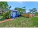 Charming blue home with a well-maintained lawn, complemented by a modern wooden fence at 301 Kingston S St, St Petersburg, FL 33711