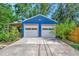 Two car detached garage showcasing ample parking space with lush landscaping and a wooden patio at 301 Kingston S St, St Petersburg, FL 33711
