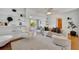 Bright living room with hardwood floors, built-in shelving, and an arched doorway to sunroom at 301 Kingston S St, St Petersburg, FL 33711