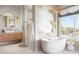 Luxurious bathroom features a soaking tub, walk-in shower, elegant fixtures, and a waterfront view at 322 Capri Blvd, Treasure Island, FL 33706