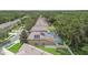 This aerial view shows a neighborhood with lush greenery, pools, and homes with solar panels on their roofs at 3530 Brook Crossing Dr, Brandon, FL 33511