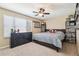 Well-lit bedroom with a queen bed, dark dresser, and shelving for collectibles at 3530 Brook Crossing Dr, Brandon, FL 33511