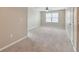 Upstairs bonus room featuring neutral carpet, a ceiling fan, and natural light from a window at 3530 Brook Crossing Dr, Brandon, FL 33511