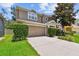 Inviting home featuring a two-car garage and lush, green shrubbery at 3530 Brook Crossing Dr, Brandon, FL 33511