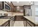 Close-up of kitchen with granite countertops, stainless steel appliances, dark cabinets, and tile backsplash at 3530 Brook Crossing Dr, Brandon, FL 33511