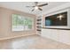 Living room showing custom built in entertainment center with white cabinets and shelving and a modern ceiling fan at 3530 Brook Crossing Dr, Brandon, FL 33511