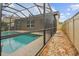 Screened-in pool with travertine deck and stone walkway along the side of the house at 3530 Brook Crossing Dr, Brandon, FL 33511