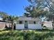 Charming white home featuring a quaint porch and a light blue front door, surrounded by lush greenery at 368 6Th Nw St, Largo, FL 33770