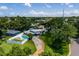 Bird's-eye view of a home with a beautiful lawn, a private pool, and mature trees, offering both privacy and curb appeal at 3700 56Th N St, St Petersburg, FL 33710