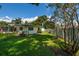 Green backyard with blue skies, lawn and mature trees at 3700 56Th N St, St Petersburg, FL 33710