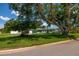 Well-maintained single-story home on a green lawn, complemented by mature trees and vibrant landscaping at 3700 56Th N St, St Petersburg, FL 33710
