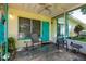 Inviting front porch with seating, a ceiling fan, and cheerful yellow and blue accents at 3700 56Th N St, St Petersburg, FL 33710