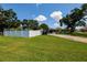Charming single-story home with a sprawling green lawn, mature trees, and white fence at 3700 56Th N St, St Petersburg, FL 33710
